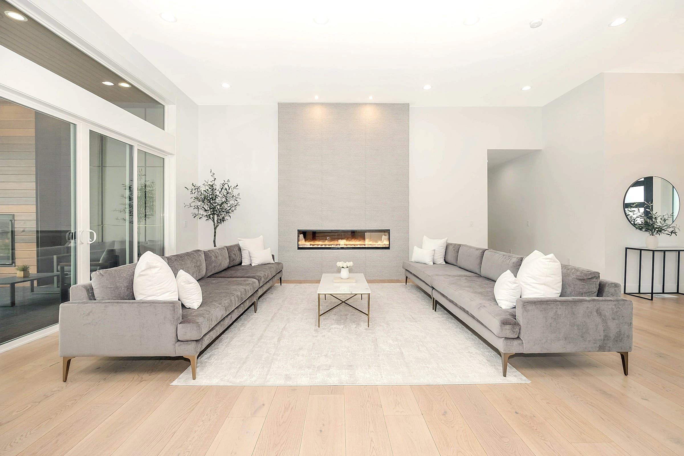 Double-height living room with a long linear hearth and low seating